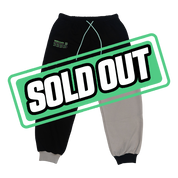 Black and gray sweatpants with neon green tech graphic on leg and elastic cuffs and waistband.