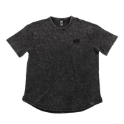Close-up of black stonewash fabric with a gray tag featuring a black stylized "GS" logo near the hem.